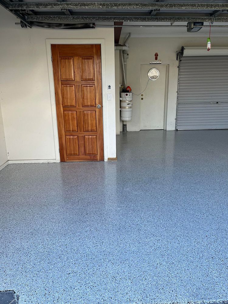 A garage with a wooden door and a gray floor