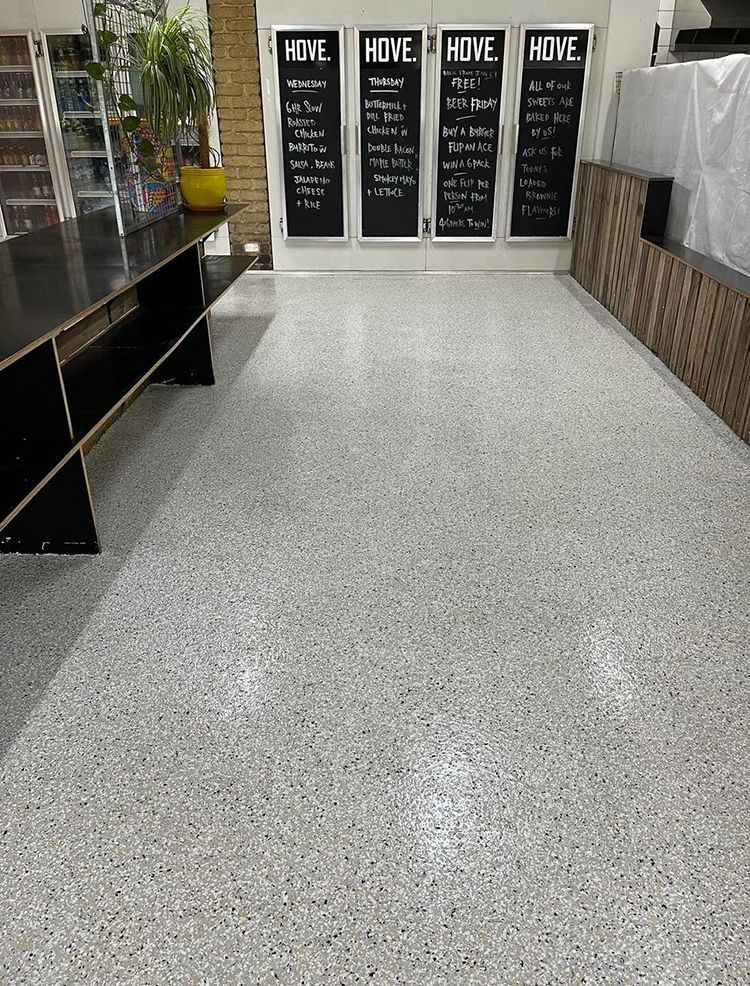 A room with a concrete floor and chalkboard signs on the wall