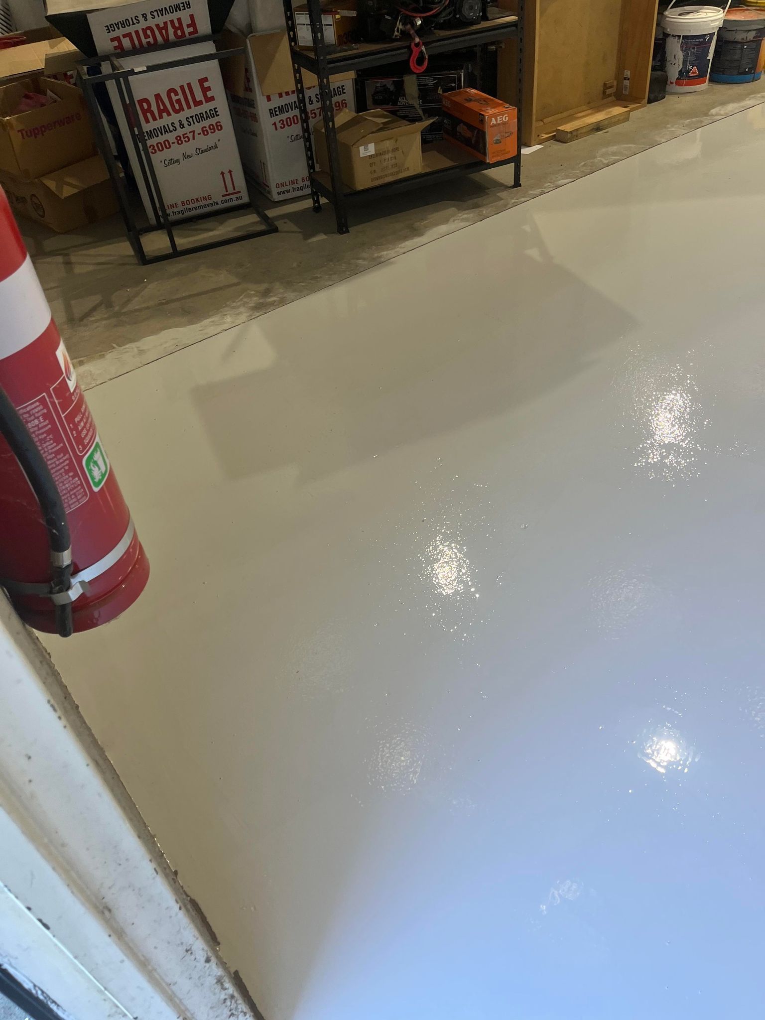 A fire extinguisher is sitting next to a white floor in a room