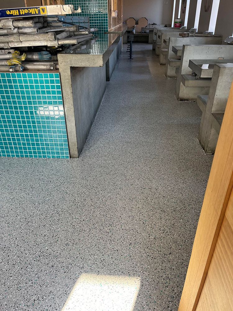 A restaurant with a gray floor and a blue tile wall