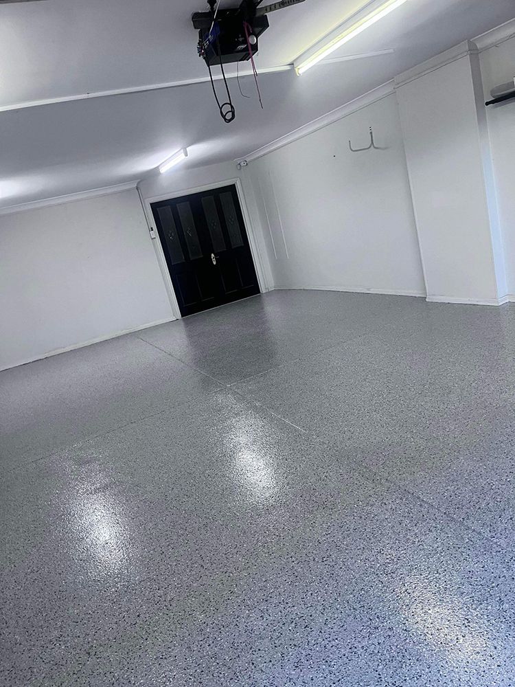 A large empty room with a gray floor and white walls