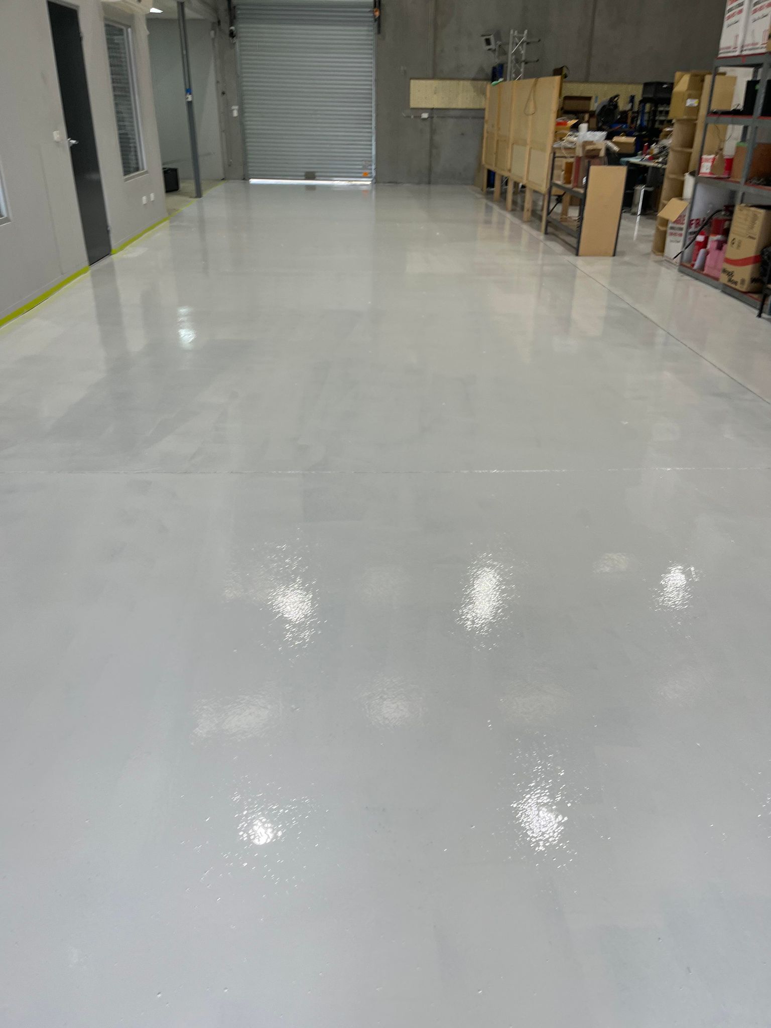 A large warehouse with a white floor and a door