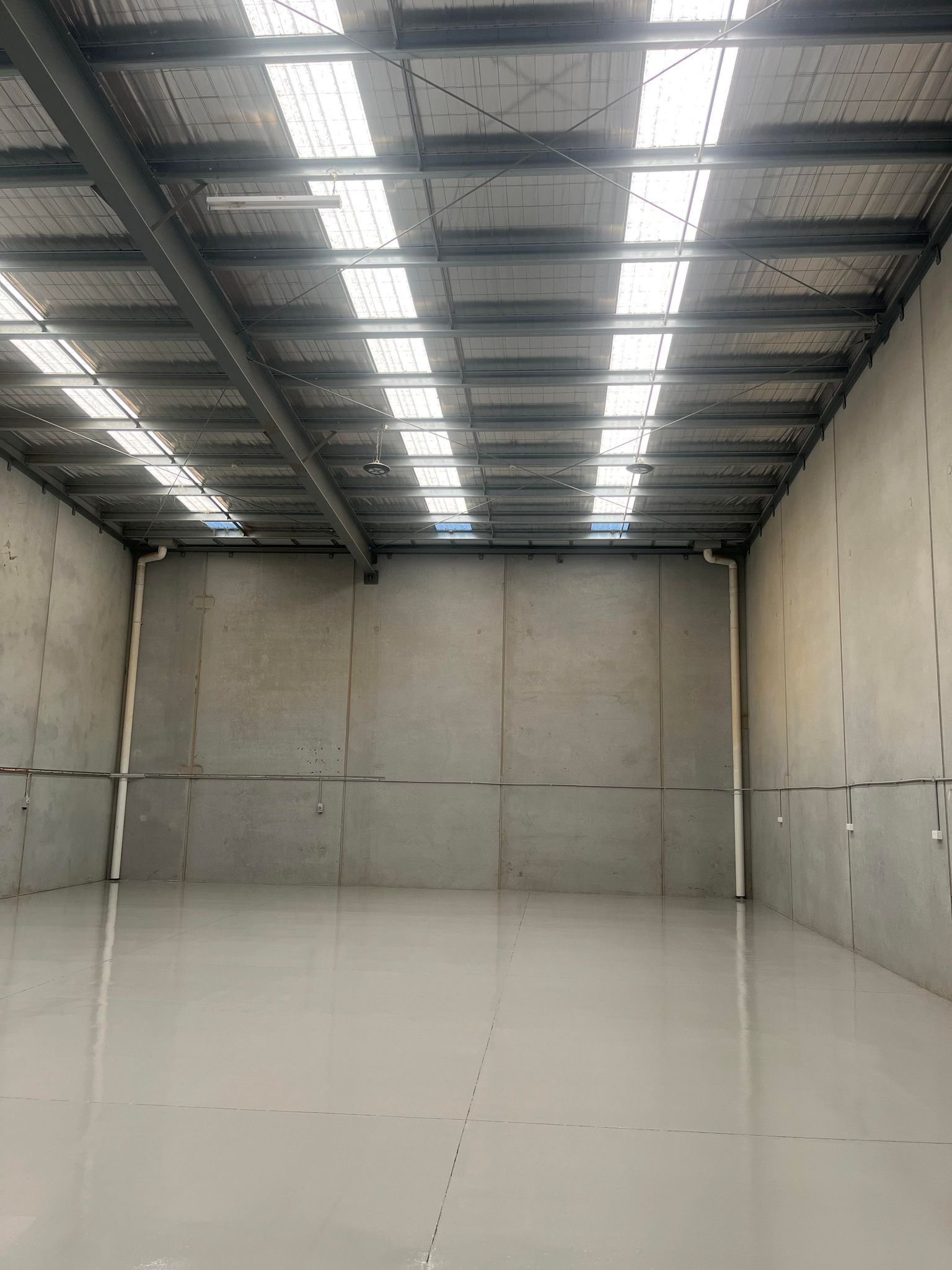 A large empty warehouse with a ceiling that has a lot of windows