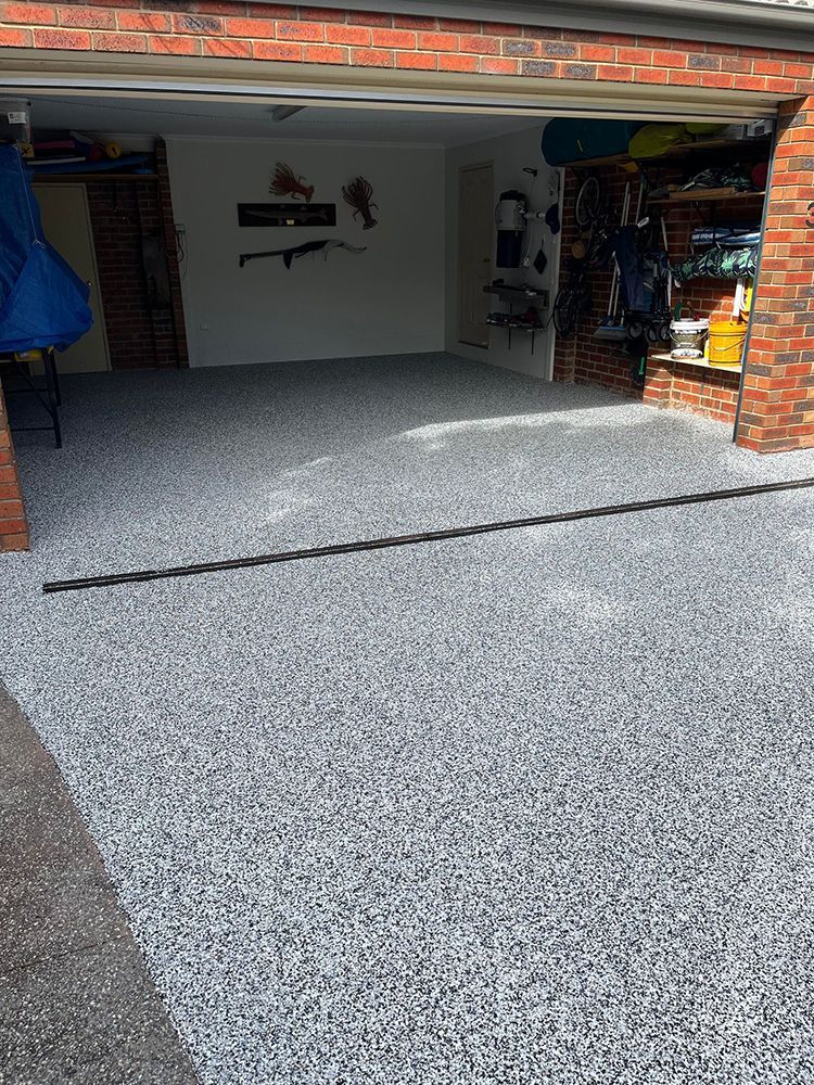 A garage with a concrete floor and a brick wall