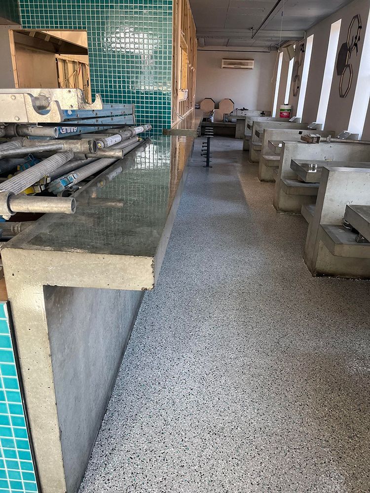 A restaurant with a long counter and tables and chairs