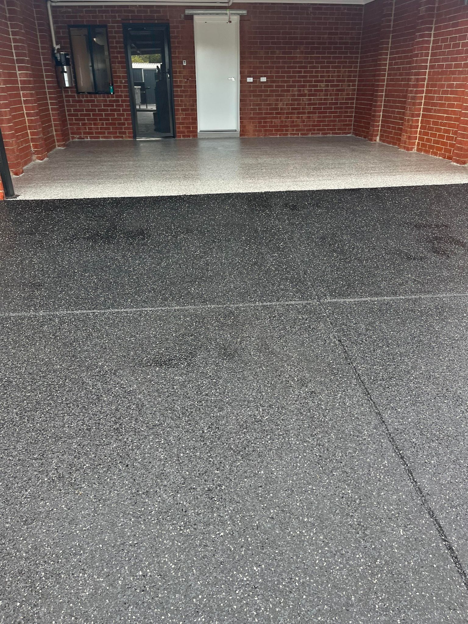 A brick building with a concrete driveway in front of it