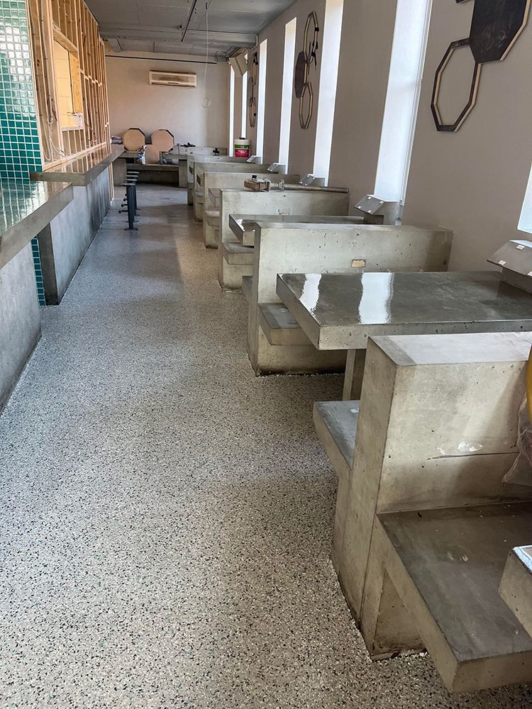 A long hallway with tables and benches in a restaurant
