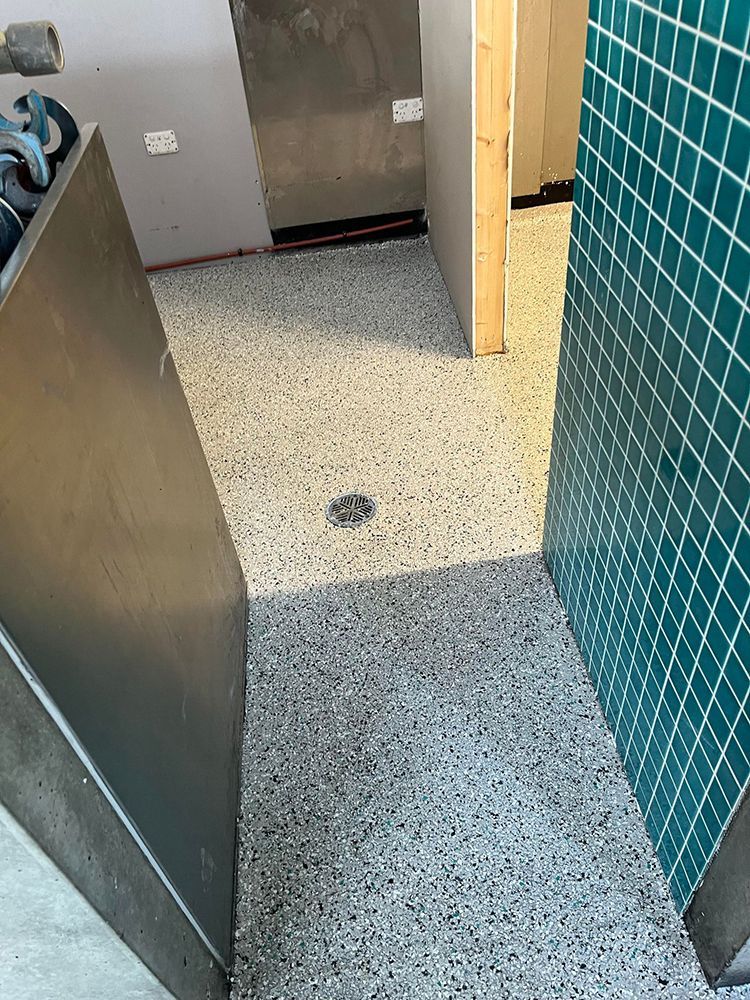 A kitchen with a stainless steel refrigerator and a tiled floor