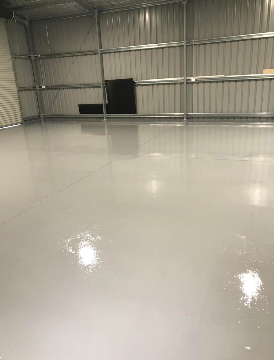A large empty warehouse with a shiny concrete floor