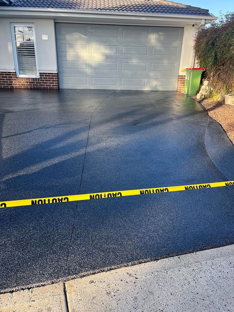 A driveway with a yellow caution tape along the side of it