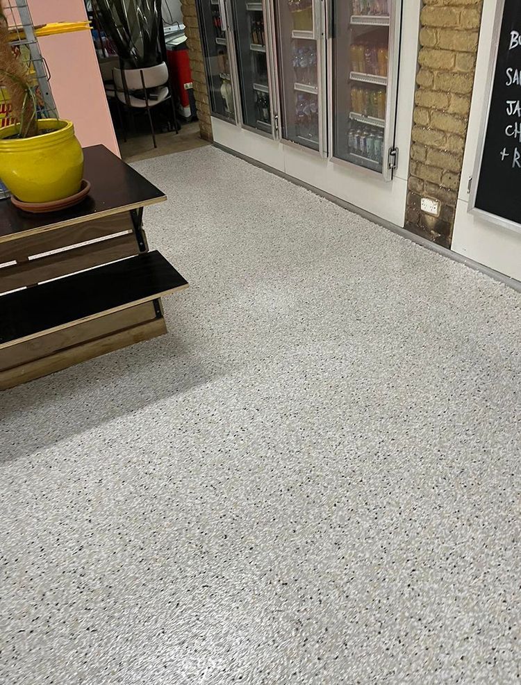 A room with a white floor and a yellow potted plant on a table