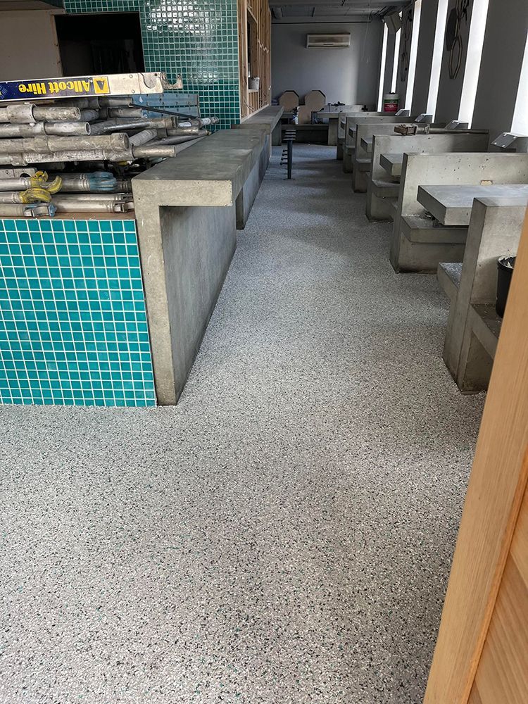 A restaurant with a concrete floor and tables and benches