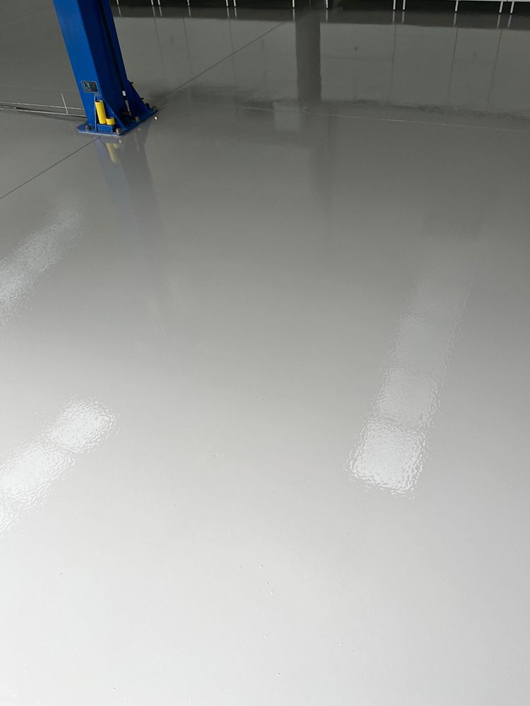 A white floor with a blue pole in the background