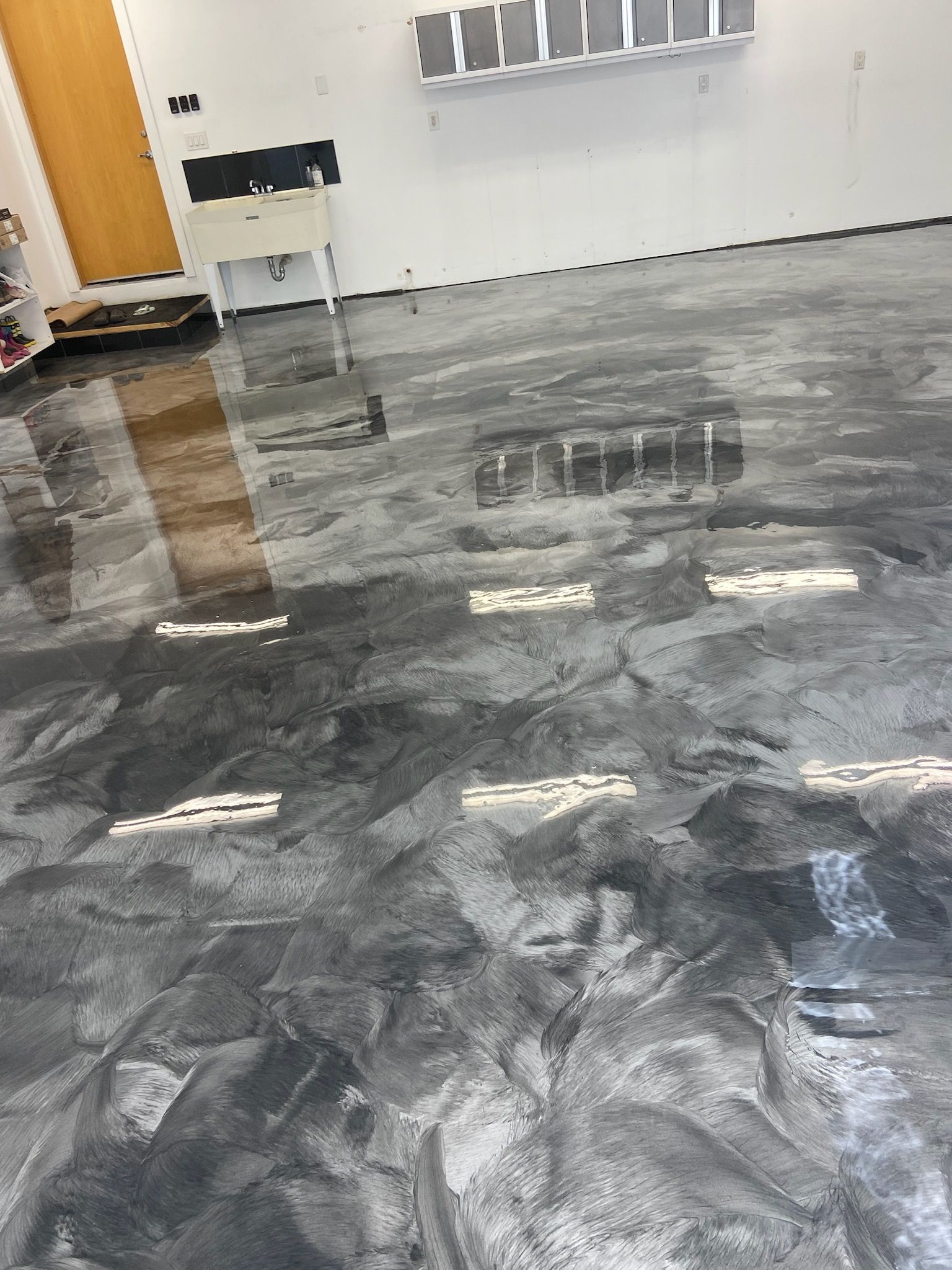 A shiny metallic floor in a room with a sink