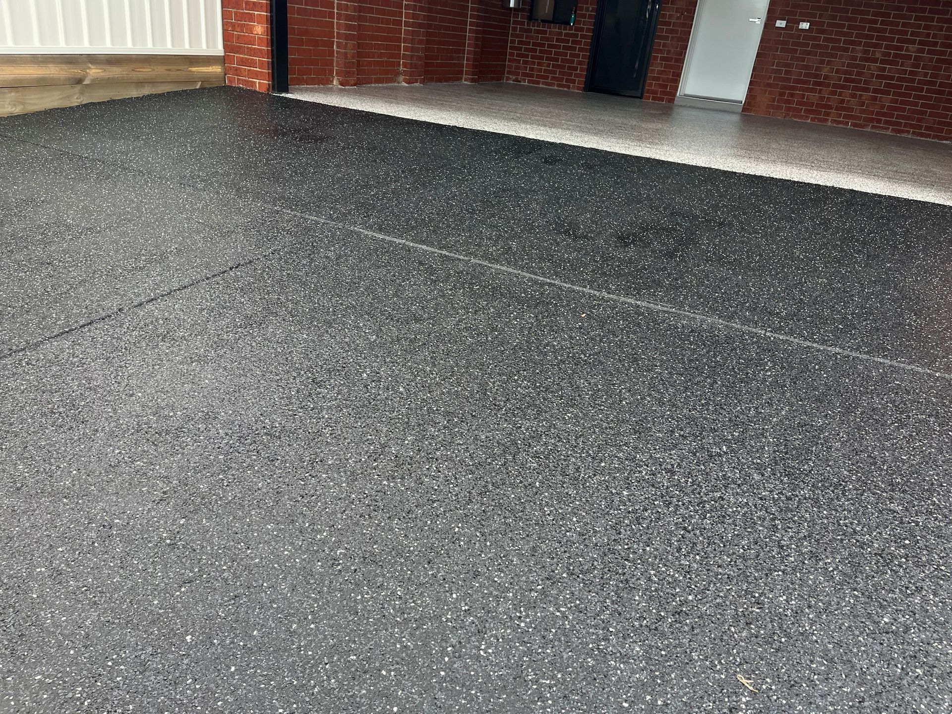 A close up of a garage floor with a brick wall in the background