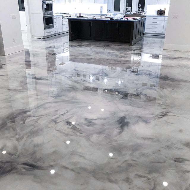 A kitchen with a marble floor and a black island