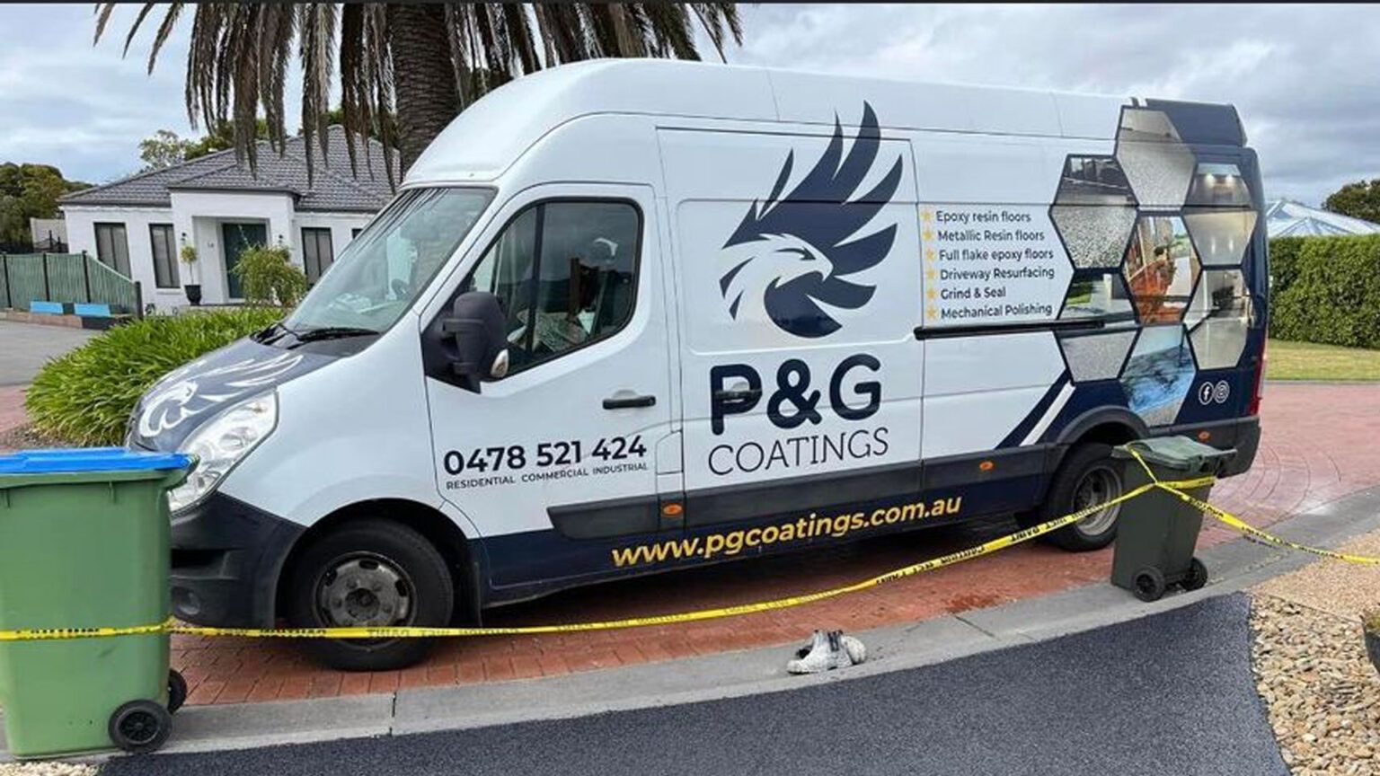 A p & g coatings van is parked on the side of the road next to a trash can