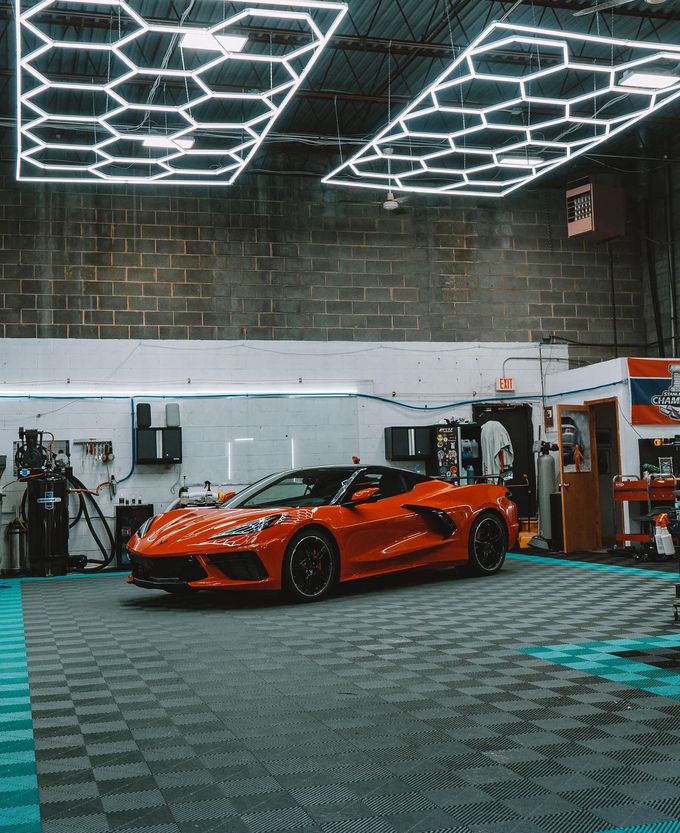 A red sports car is parked in a garage.