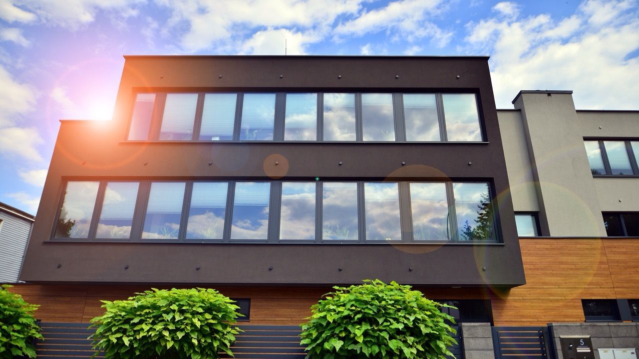 A large building with a lot of windows and trees in front of it.