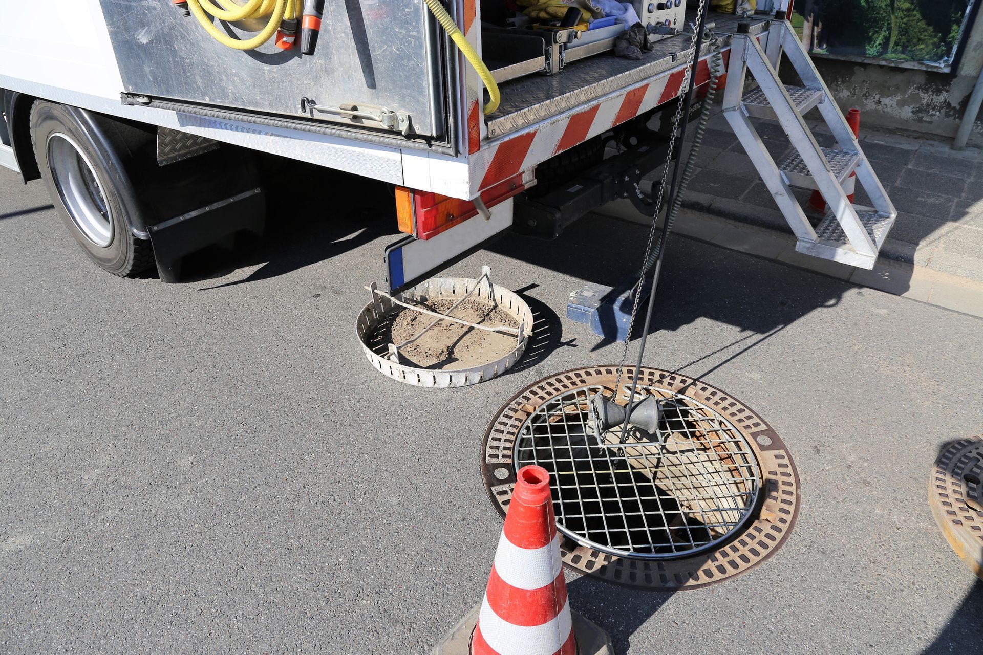 A manhole cover is sitting on the side of the road next to a truck.