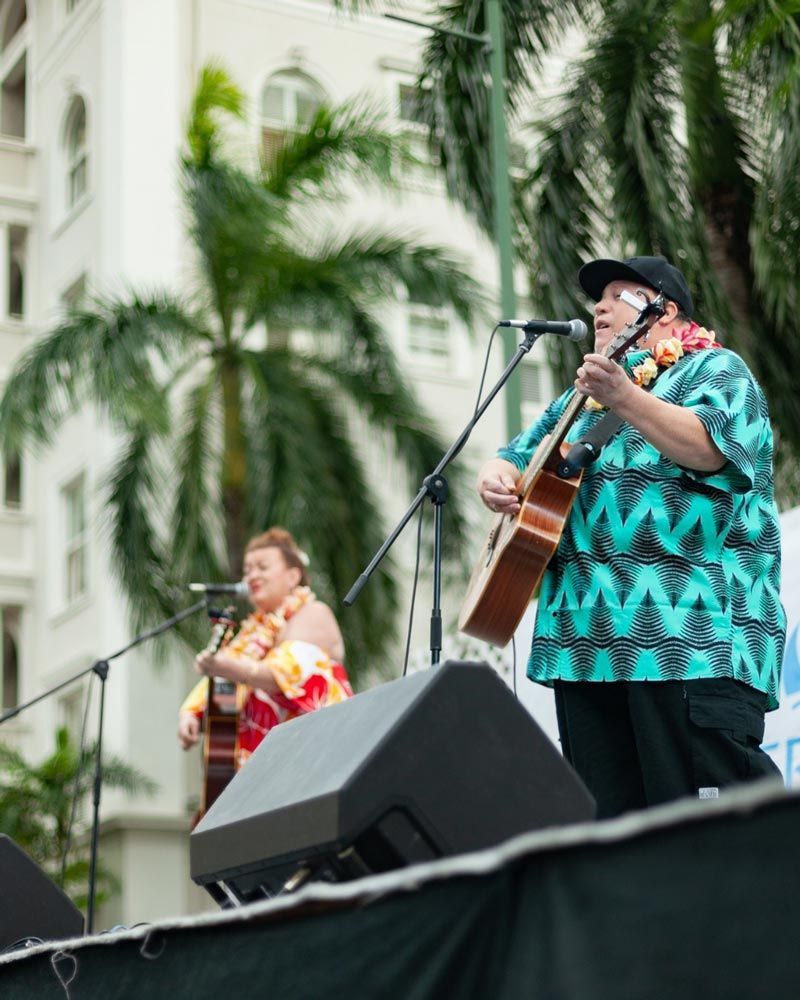 A man singing into a microphone while holding a guitar