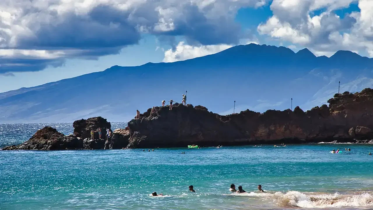 Kids jumping off Back Rock at the north end of Kaanapali Beach, Maui, Hawaii.