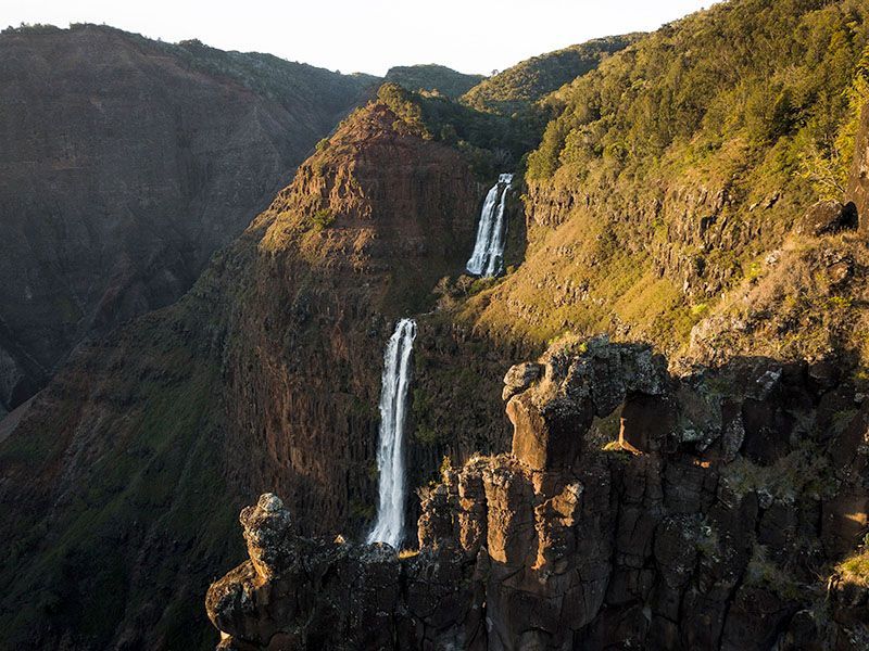 There are two waterfalls on the side of a mountain.