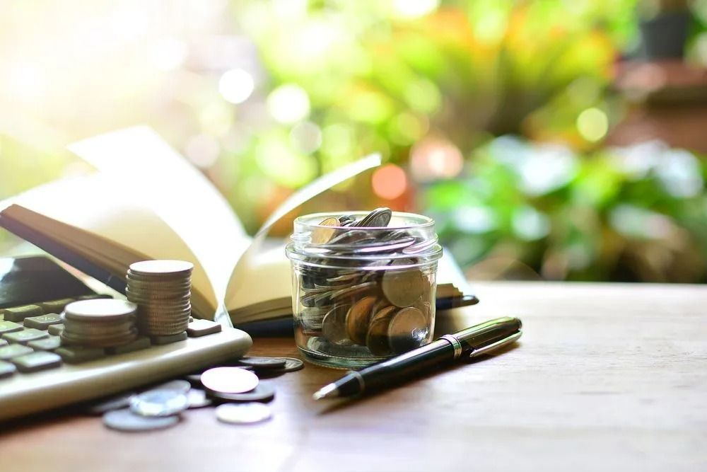 Jar Filled With Coins Sits on a Wooden Table