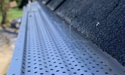 A close up of a metal gutter on a roof.