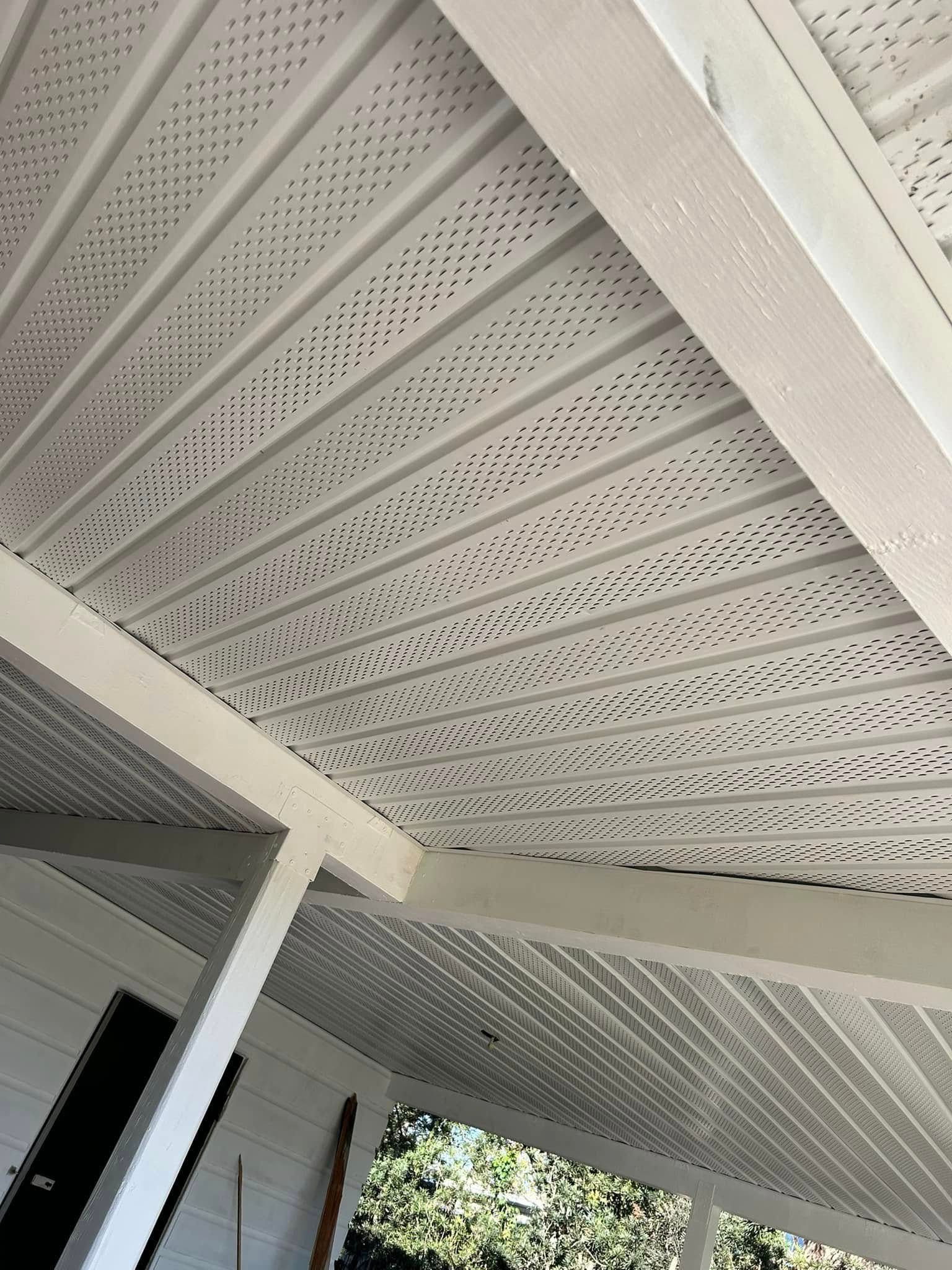 A white ceiling with holes in it is on a porch.