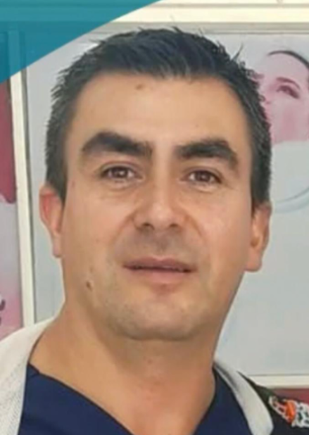 Dentista examinando los dientes de un paciente con un espejo dental y luz en una clínica.