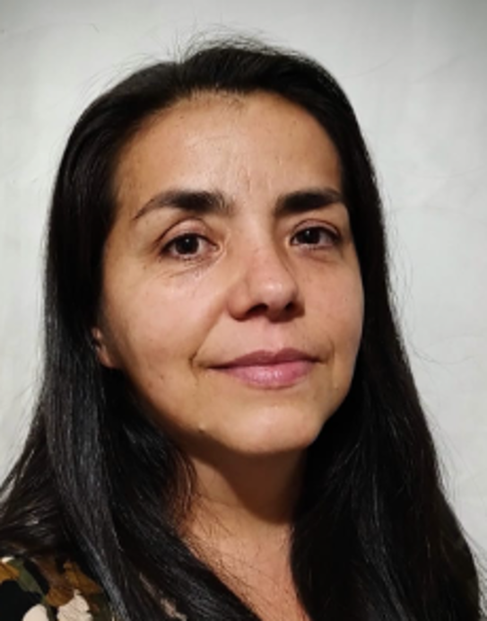 Dos profesionales dentales con batas azules examinan una hilera de modelos de dientes en una clínica.