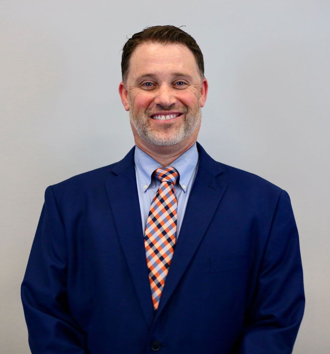 A man in a suit and tie is smiling for the camera