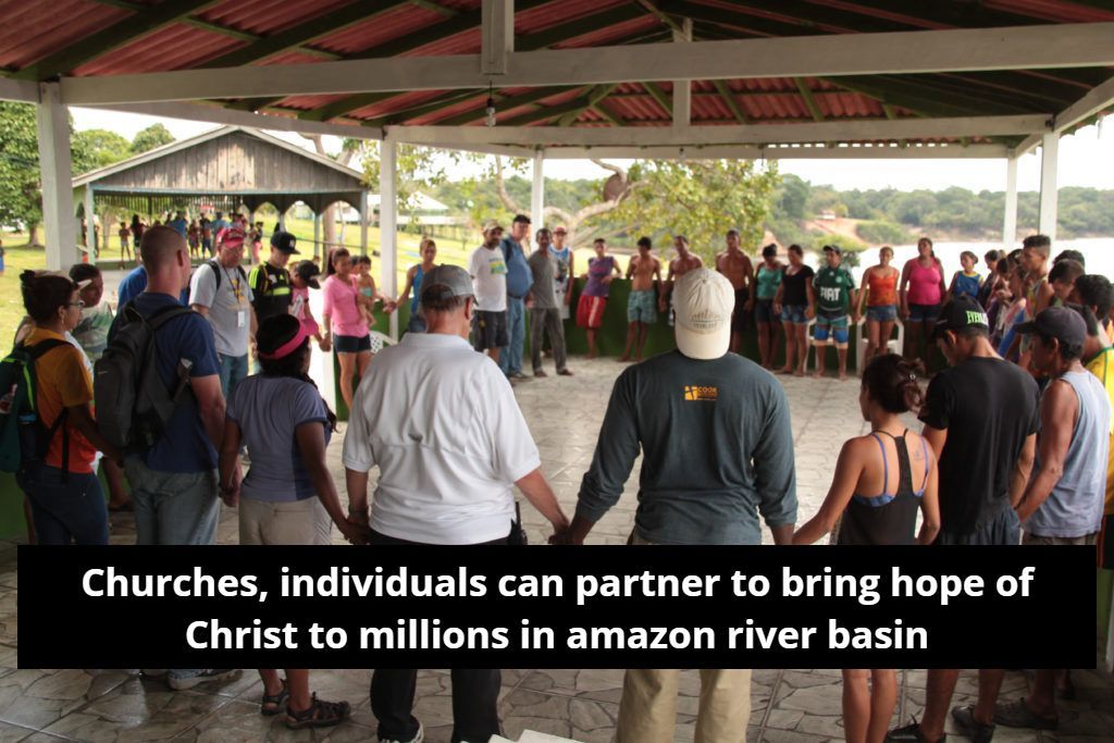 A group of people are standing in a circle holding hands