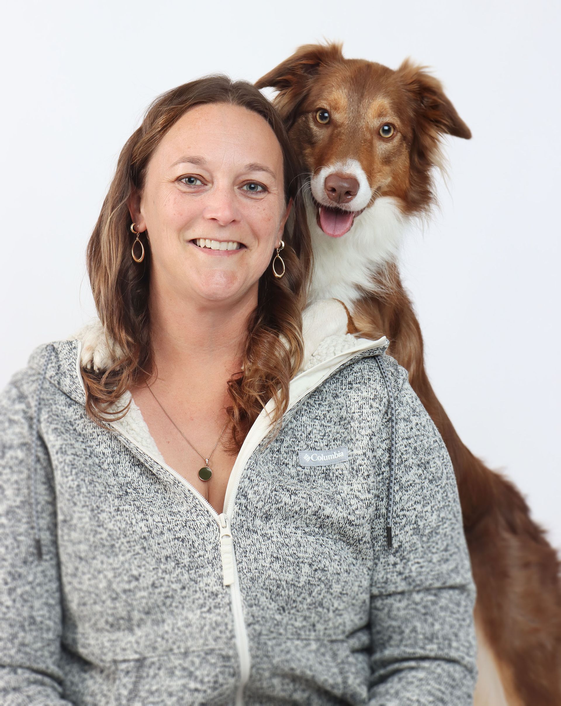 a close up of a woman 's face wearing a pink jacket and smiling .