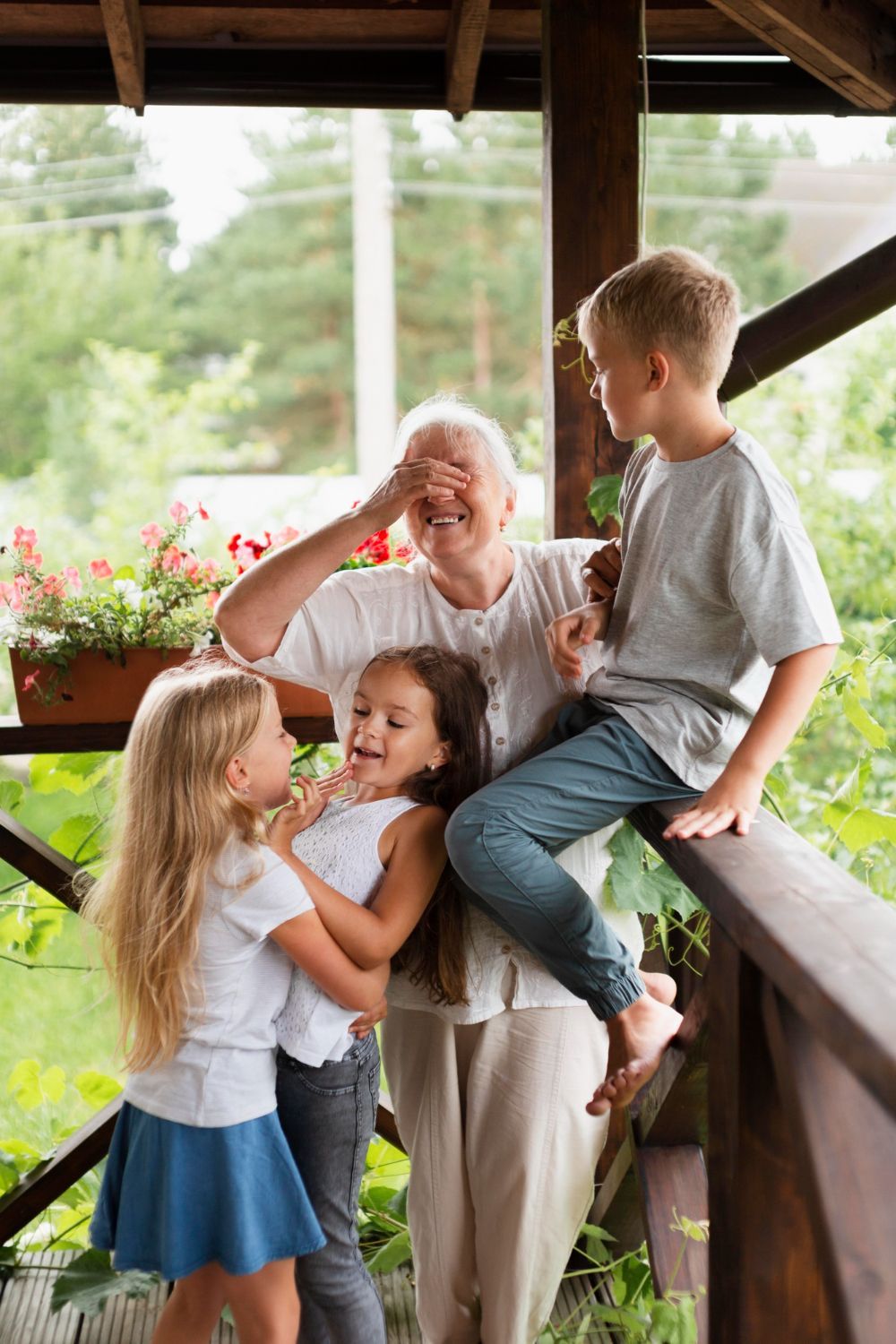 A group of children are sitting on a porch with their grandmother.