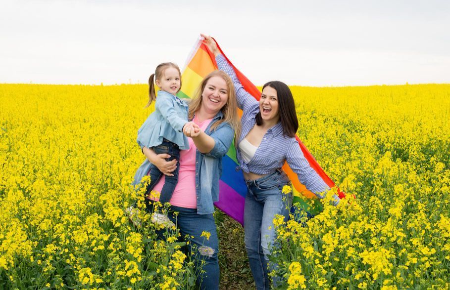 An elderly couple and a young girl are sitting on a park bench.