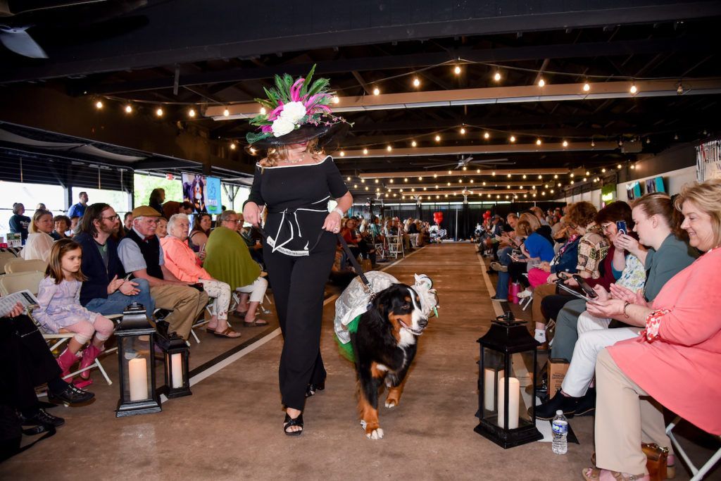 Runway pair in a black, white and emerald green dress and hats that pop