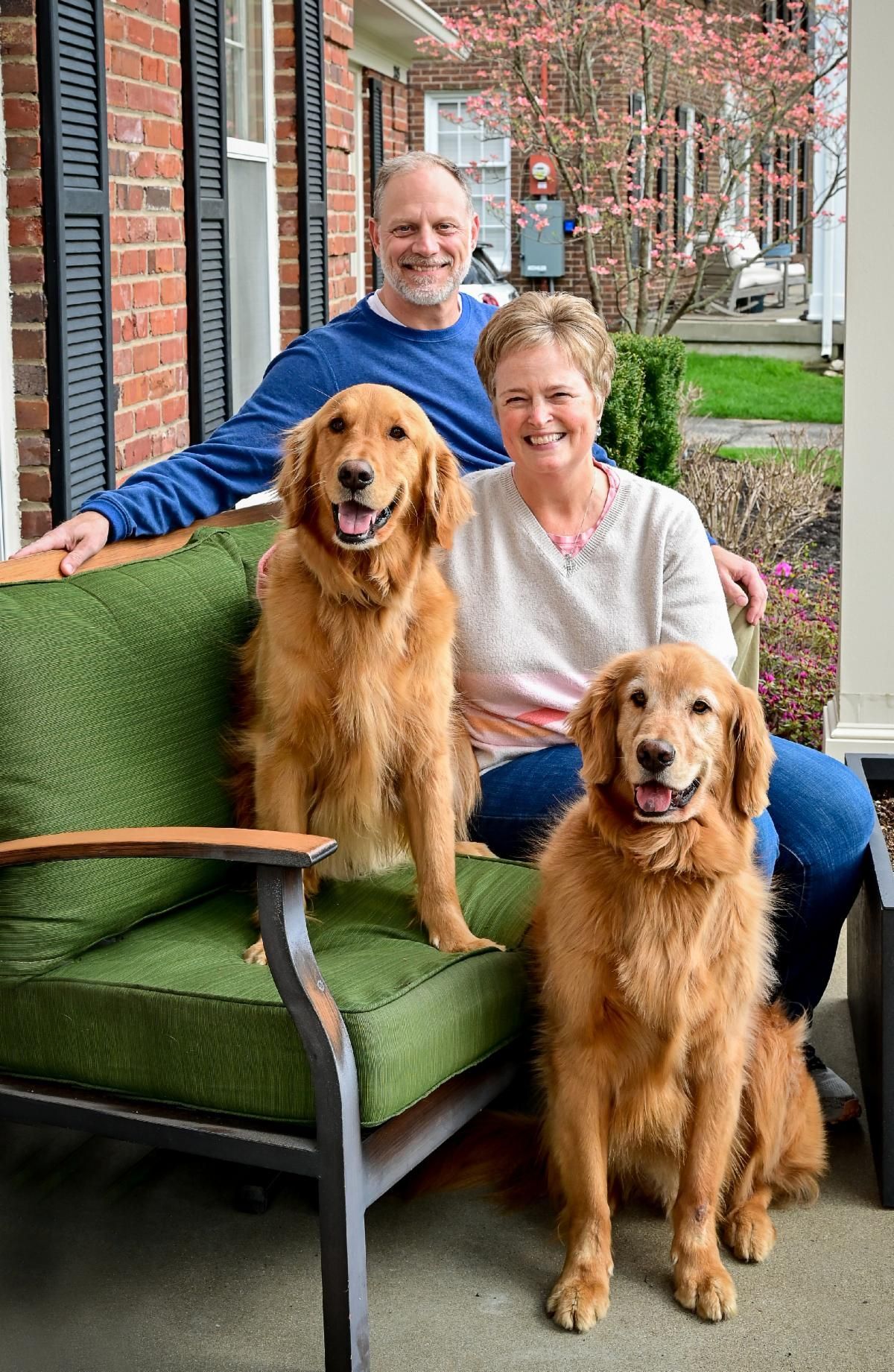 Family seated with two Golden Retriever Therapy Dogs