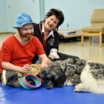 Cedar Lake Lodge resident plays with a therapy poodle