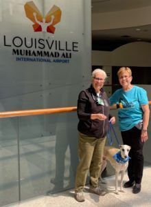 Team Standing in front of the Airport Terminal Signage