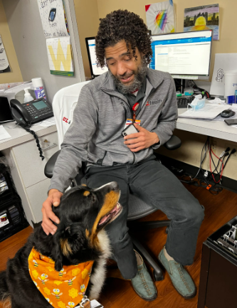 Hospital employee petting a therapy dog