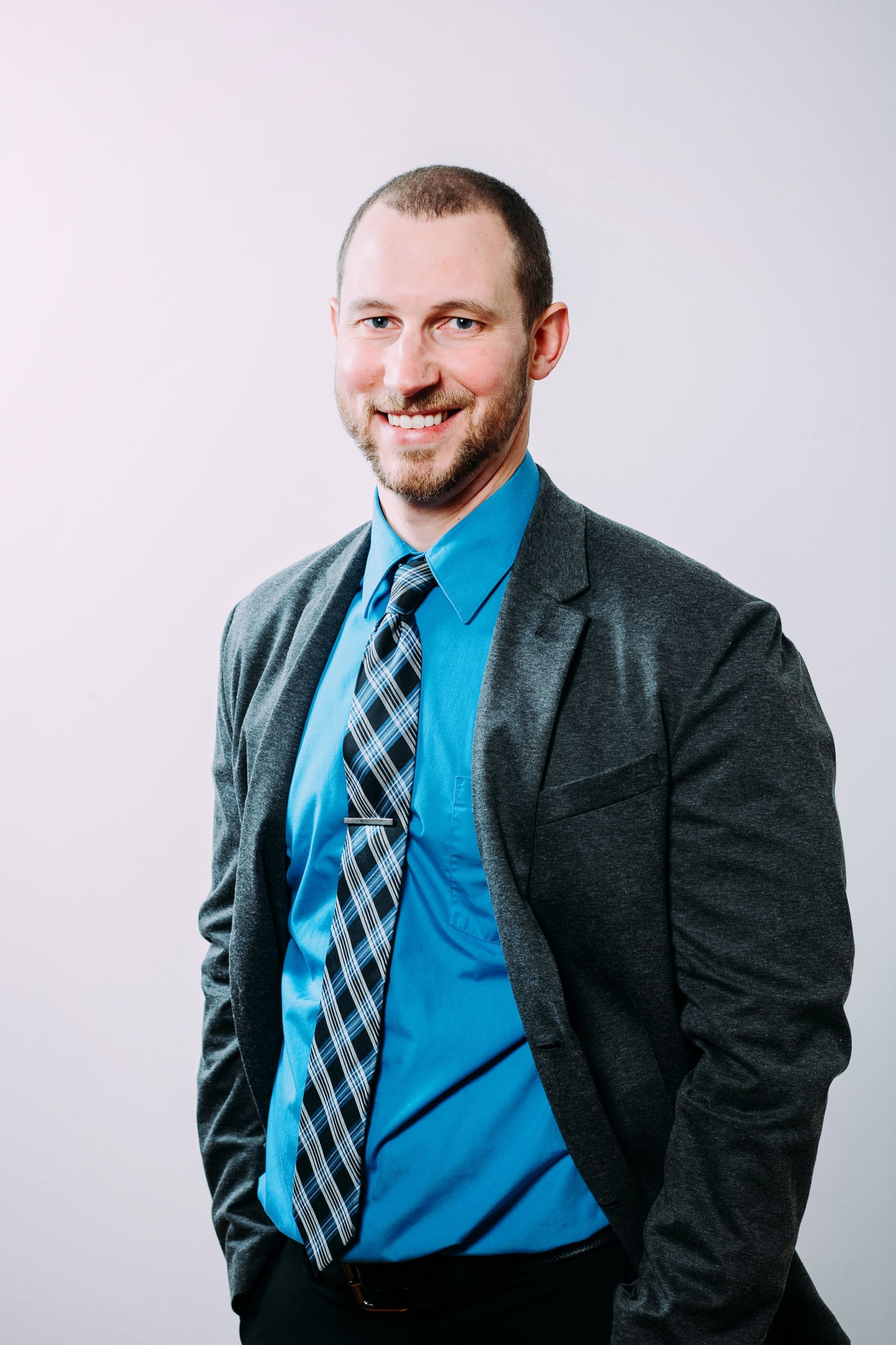 A man in a suit and tie is smiling for the camera.