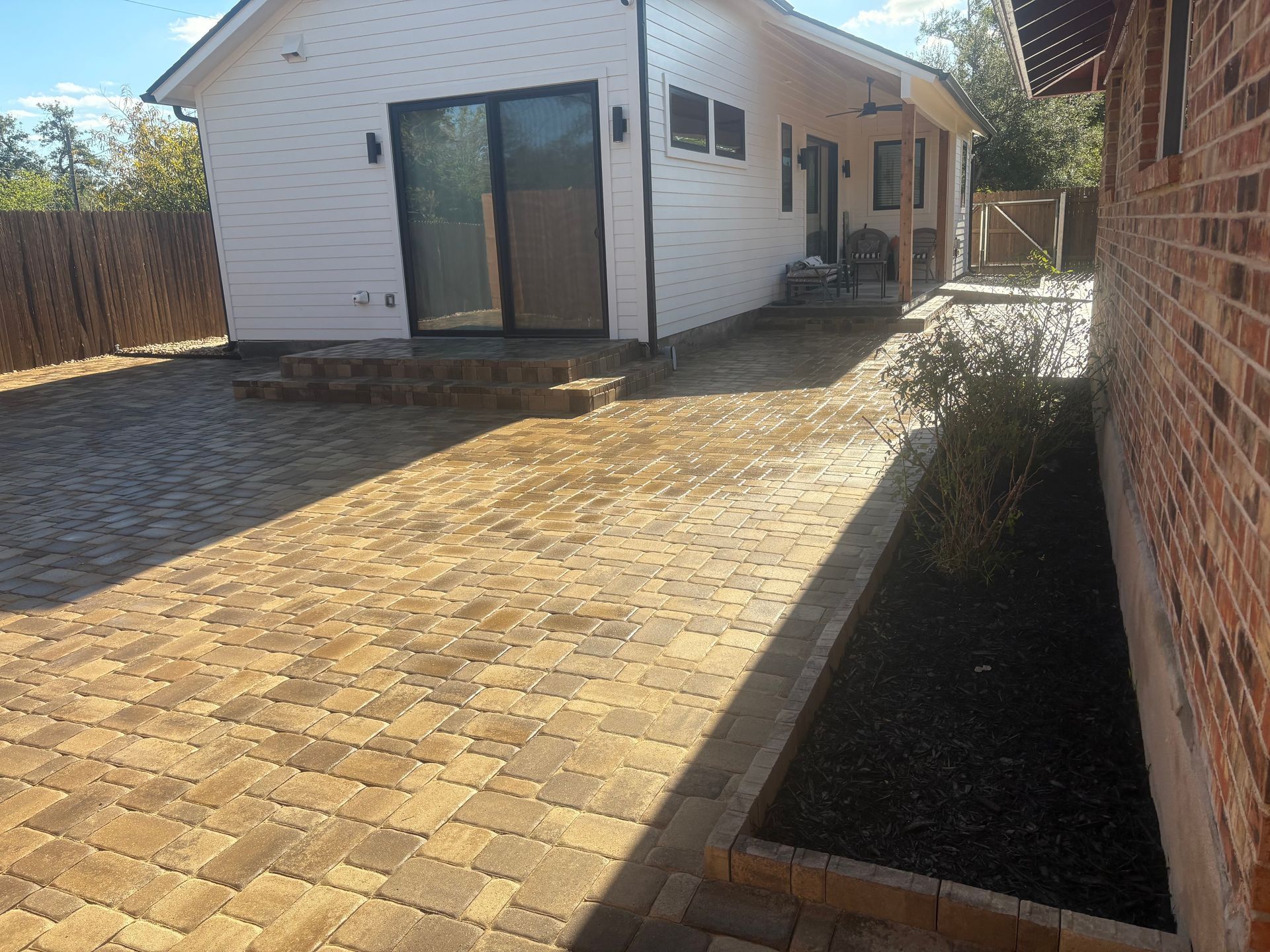 A man is working on a brick wall with a hammer.
