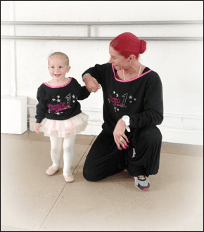 For dance classes for children in Whitfield call 0161 796 6005 woman crouching next to a young girl wearing a ballet outfit with a white wall behind