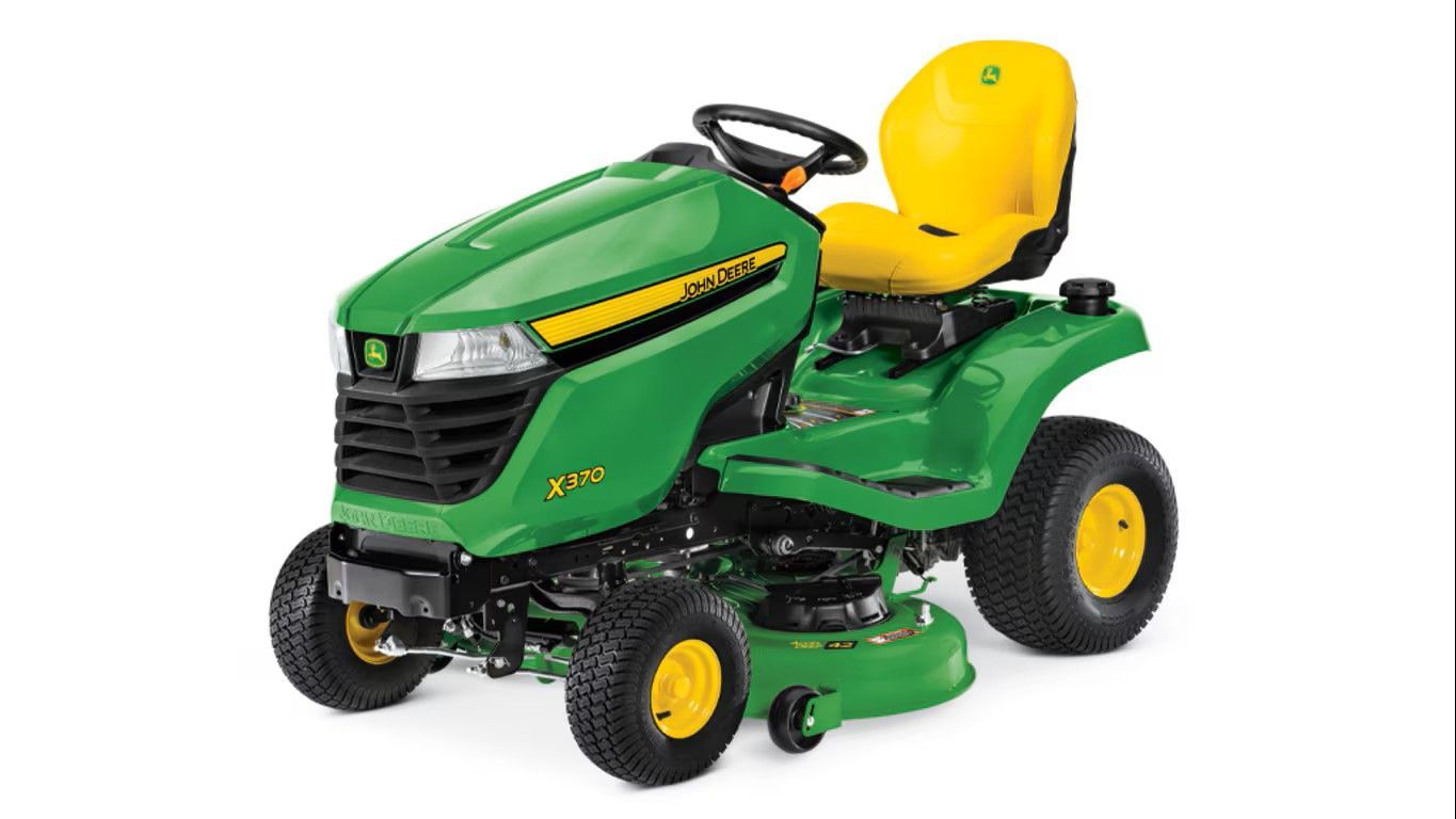A green and yellow John Deere Z325E zero-turn riding lawn mower on a white background.