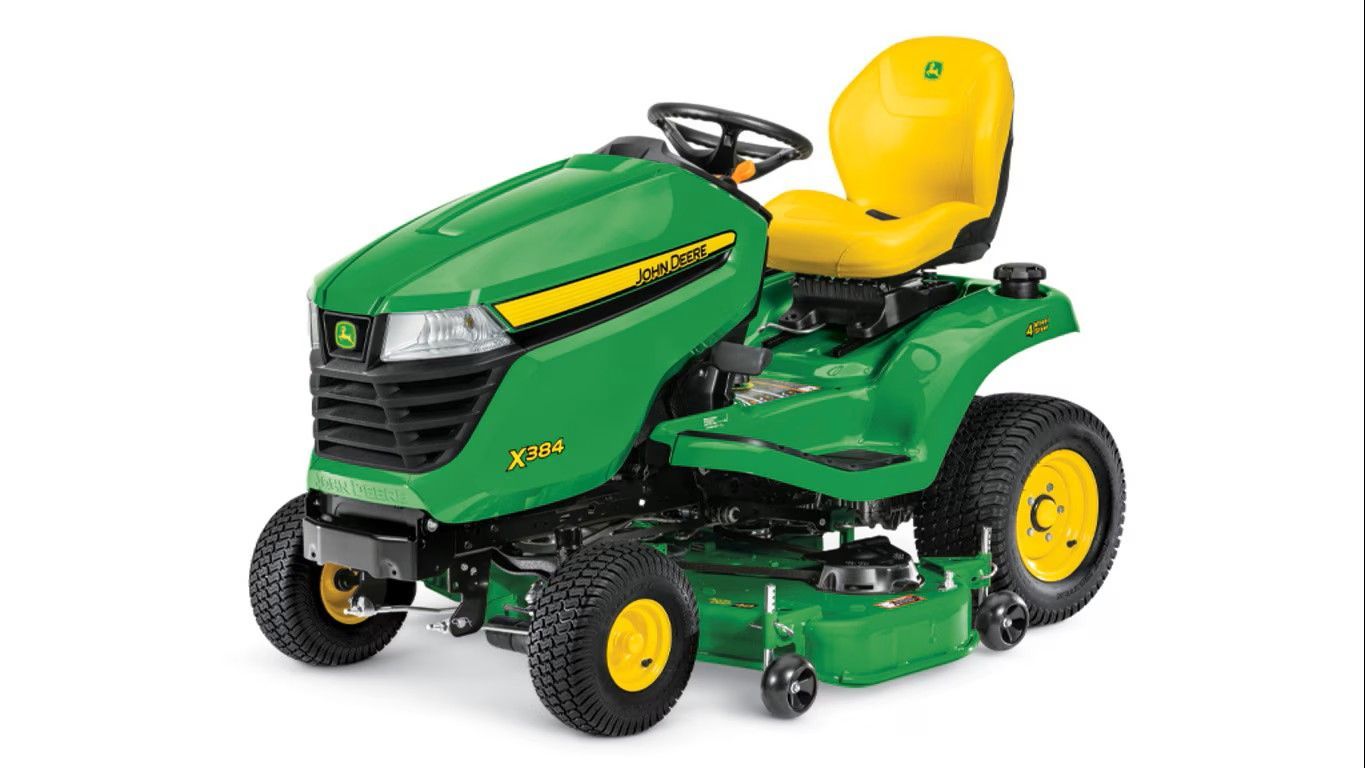 A green and yellow John Deere Z325E zero-turn riding lawn mower on a white background.