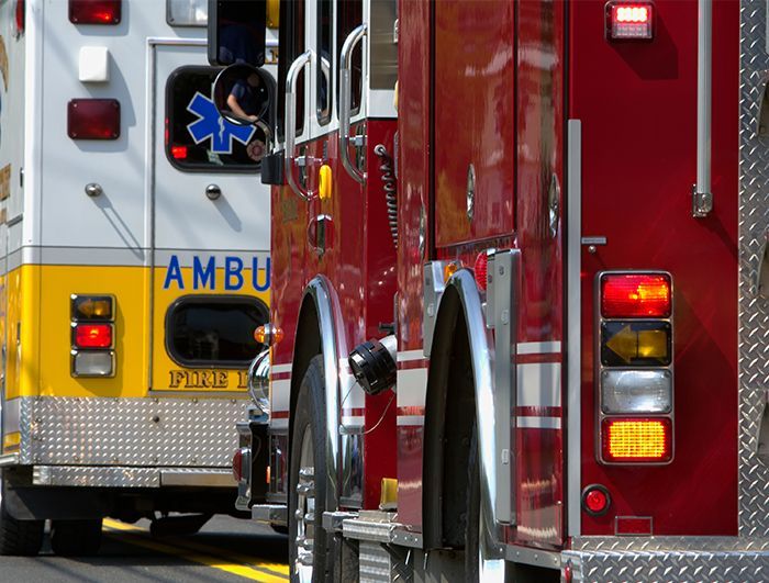 An ambulance and a fire truck are parked next to each other on the street.