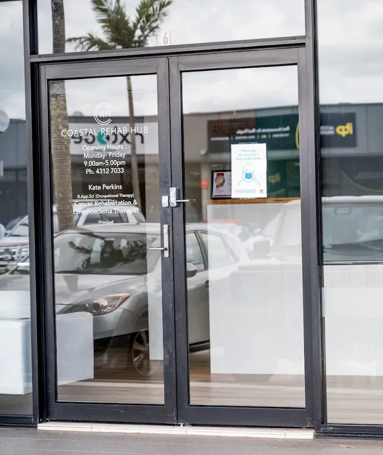 Three people in teal scrubs stand together indoors, smiling.