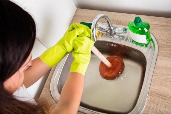 Woman Holding Cleaning Pump — Lansing, MI — Michigan Plumbing